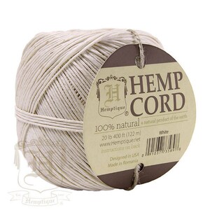 May include: A ball of white hemp cord with a brown label that reads "Hemp Cord 100% natural a natural product of the earth 20 lb 400 ft (122 m) www.Hemptique.net instructions on back White Designed in USA Made in Romania".