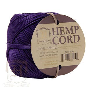 May include: A spool of dark purple hemp cord, 100% natural, with a label that reads "Hemp Cord" and "Dark Purple". The label also includes the brand name "Hemptique" and the text "20 lb 400 ft (122 m)".