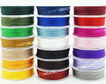 Könnte beinhalten: Eine Sammlung von Spulen mit gewachstem Garn in verschiedenen Farben, darunter Grün, Blau, Rot, Rosa, Weiß, Schwarz, Braun, Gelb und Grau. Die Spulen sind in drei Reihen angeordnet, wobei jede Reihe sechs Spulen enthält. Die Spulen sind mit dem Text "CRAFT BEADS" beschriftet.