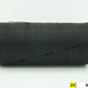 May include: A spool of black waxed cord, labeled "20 Black". The cord is tightly wound and has a textured surface.