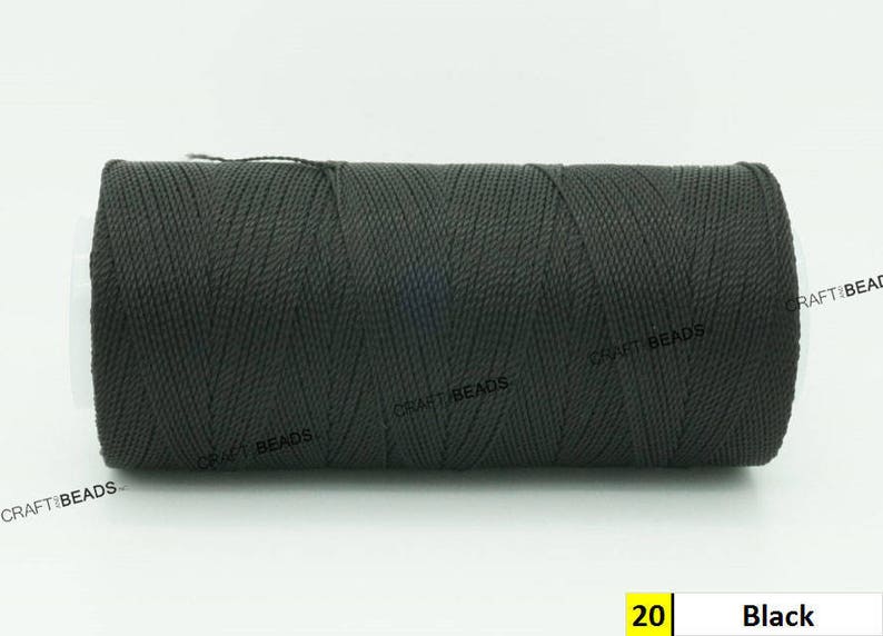 May include: A spool of black waxed cord, labeled "20 Black". The cord is tightly wound and has a textured surface.