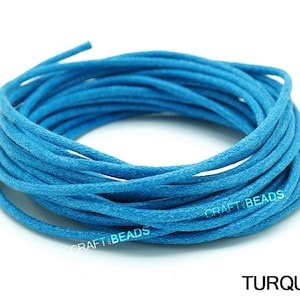 May include: A spool of turquoise blue waxed cord. The cord is wound tightly and is ready to be used for crafting projects.