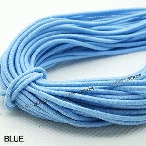 K&ouml;nnte beinhalten: Nahaufnahme einer Spule mit hellblauem Gummiband. Das Band ist fest gewickelt und bereit f&uuml;r Bastelarbeiten.