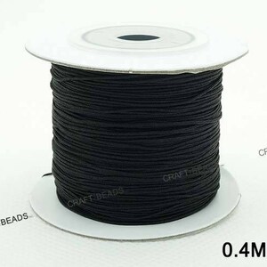 May include: A spool of black elastic cord, 0.4mm thick, for crafting and jewelry making.