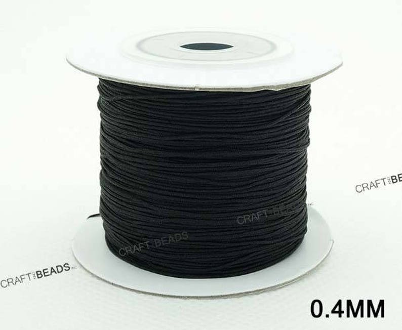 May include: A spool of black elastic cord, 0.4mm thick, for crafting and jewelry making.