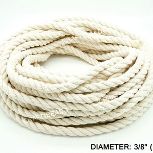 May include: A close-up of a coil of natural white cotton rope, 3/8 inch in diameter. The rope is tightly wound and has a smooth, natural texture.
