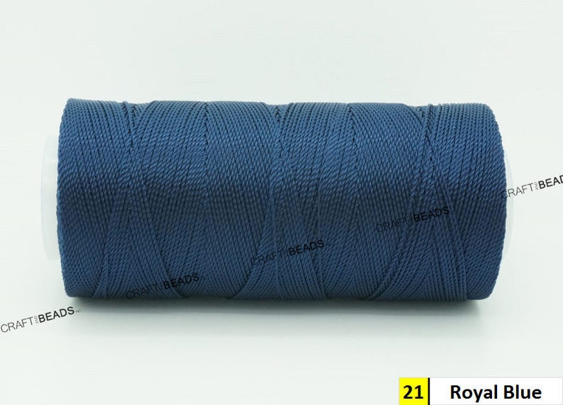 May include: A spool of royal blue waxed cord, a type of thread used for crafts and jewelry making.