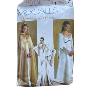 May include: A McCall's Evening Elegance sewing pattern envelope featuring illustrations of two white floor-length gowns with gold trim and a hooded gold cape. The package displays the brand name McCall's and the text Evening Elegance at the top.