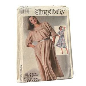 May include: A vintage Simplicity sewing pattern featuring a woman in a polka dot dress with a belt. The pattern includes the text "E-A-S-Y TO SEW" and "F-A-C-I-L-E A COUDRE". The pattern size is N (10+12+14).