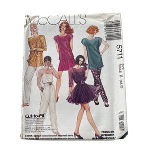 May include: A vintage McCall's sewing pattern envelope featuring illustrations of various sequined and patterned outfits. The envelope includes the text "McCall's", pattern number 5711, and "Cut-to-Fit" instructions. The size is A (6,8,10).
