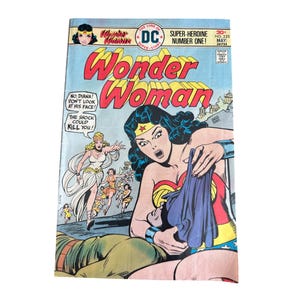 May include: A vintage comic book cover featuring Wonder Woman. The cover art shows Wonder Woman in her classic costume, with the title "Wonder Woman" in large, bold letters. The comic book is number one in the Super-Heroine series.