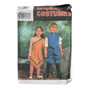 Peut inclure: Patron de couture Simplicity Costumes 5736, taille A. L'emballage présente deux tenues : une robe beige à franges et un gilet bleu avec pantalon assorti. Le texte inclut la marque Simplicity, le mot COSTUMES et le numéro de modèle 5736.