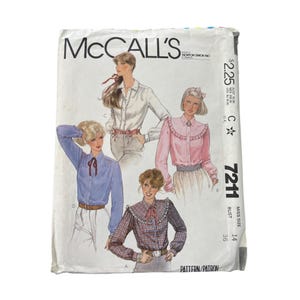 May include: Vintage McCall's sewing pattern featuring illustrations of blouses. The pattern envelope shows four different blouse designs in various colors, including blue, pink, and plaid. The envelope has text and a price tag.
