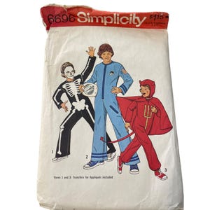 May include: Vintage Simplicity sewing pattern envelope featuring illustrations of three children's Halloween costumes. The costumes include a skeleton, an astronaut, and a devil. The envelope is white with red and black text.