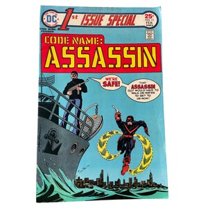 May include: A vintage comic book cover titled "Code Name: Assassin." The cover features a ship with two figures, one holding a gun. The title is in large yellow letters on a red background. The comic is from DC Comics.