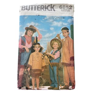 May include: Butterick 6852 sewing pattern envelope featuring illustrations of four individuals wearing tan suede-like fringe outfits and cowboy hats. The package includes text labels A, B, C, and D, with the brand name Butterick and number 6852 printed at the top.