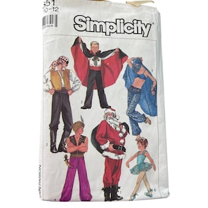 May include: A vintage Simplicity sewing pattern packet featuring illustrations of various costume designs. The costumes include a pirate, a vampire with a red cape, a Santa Claus, and a ballerina. The packet is white with black text.