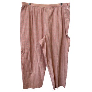 May include: Red and white plaid pants with an elastic waistband and a zipper closure. The pants are made of a lightweight fabric and have a relaxed fit. The plaid pattern is a classic design.