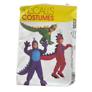 May include: A McCall's Costumes pattern packet featuring three children's dinosaur costumes in green, purple, and red. The packet includes the size range (7-8) and the number 2335. The costumes have attached tails and hoods.