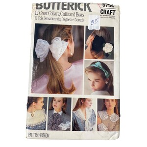 May include: A vintage Butterick craft pattern, featuring images of collars, cuffs, and bows. The cover showcases various styles, including a large lace bow, a black velvet bow with a flower, and a teal headband. The pattern number is 5754.