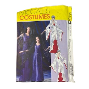 May include: A McCall's Costumes sewing pattern packet. The packet features illustrations of women's costumes, including a long purple dress and a white and red spiderweb-themed gown. The packet is yellow and purple.