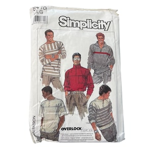 May include: A Simplicity sewing pattern packet featuring illustrations of various men's tops. The packet includes a red turtleneck, striped shirts, and a gray sweatshirt with a red stripe. The text "Simplicity" is prominently displayed.