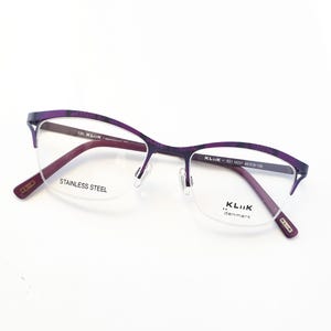 Puede incluir: Gafas moradas y burdeos con un diseño semi-sin montura. Las monturas presentan un acabado estampado y el texto "STAINLESS STEEL" es visible en la lente. La marca "KLiiK" está impresa en la patilla.