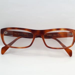 Puede incluir: Gafas marrones de carey con montura rectangular. Las gafas tienen lentes transparentes y un puente de cerradura. La marca "FACE FACE PARIS" es visible en la montura. El modelo es DJINN 2 58017 COL 862.