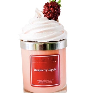 Pode incluir: Uma vela de cera de soja rosa em um pote de vidro com tampa prateada. A vela é coberta com um creme branco semelhante a chantilly e uma framboesa vermelha. O rótulo diz "Raspberry Ripple" e inclui o texto "100% Soy Wax Scented Candles Hand Poured in Scotland https://donutattakary.com".