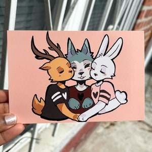 Puede incluir: Un fondo rosa con tres animales de dibujos animados abraz&aacute;ndose. Un ciervo con cuernos marrones, un lobo con pelaje azul y un conejo con pelaje blanco. Los tres animales llevan camisas negras con rayas blancas y un dise&ntilde;o de coraz&oacute;n.