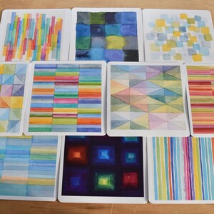 May include: A set of square art prints with watercolour abstract geometric designs. The prints display colourful patterns, including vertical stripes, squares, and triangles in shades of blue, yellow, green, and red.