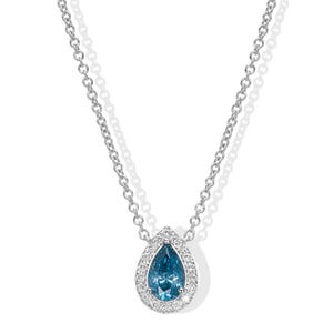 Könnte beinhalten: Eine silberne Halskette mit einem tropfenförmigen, blauen Edelsteinanhänger, umgeben von kleinen, klaren Steinen. Der Anhänger hängt an einer zarten Kette. Der Schmuck ist vor einem weißen Hintergrund platziert.
