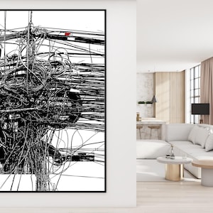 May include: Black and white abstract art print featuring a complex network of lines and shapes, resembling tangled wires or cables. The artwork is framed in a black border, creating a striking contrast against the white background. The print is displayed in a modern living room setting.