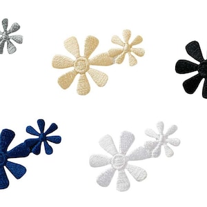 May include: Six pairs of iron-on flower patches in various colours, including black, white, grey, blue, and beige. Each pair features two flowers of different sizes.