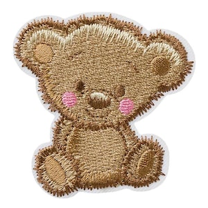 Könnte beinhalten: Gestickter brauner Teddybär-Patch mit rosa Wangen. Der Bär sitzt mit seinen Pfoten vor sich.