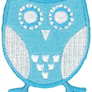 Könnte beinhalten: Eine blaue Filz-Eulen-Applikation mit weißen Nähten. Die Eule hat große Augen, einen kleinen Schnabel und einen runden Körper.