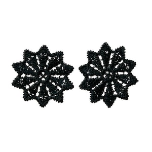 May include: A pair of black lace earrings in the shape of a star.