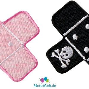 May include: Two iron-on patches shaped like bandages. One is pink with a white heart and the other is black with a white skull and crossbones.