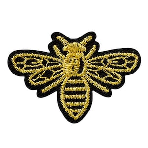 May include: A black and gold embroidered bee patch. The bee is outlined in black with gold wings and a gold body.