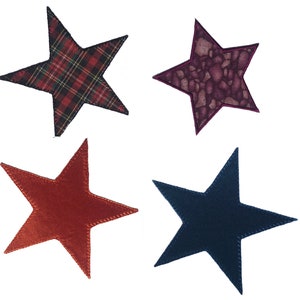 Könnte beinhalten: Vier Stoffsterne in verschiedenen Farben und Mustern. Die Sterne sind rot, blau, orange und lila. Der rote Stern hat ein Karomuster, der blaue Stern ist einfarbig, der orange Stern ist einfarbig und der lila Stern hat ein geflecktes Muster.