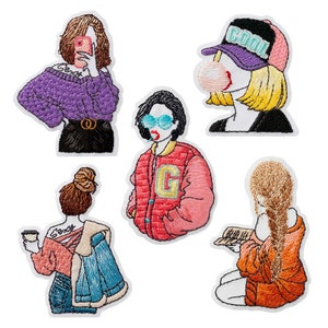 Può includere: Cinque toppe ricamate da stirare che rappresentano diverse figure femminili. Una figura indossa un maglione viola e pantaloni neri, un'altra indossa una giacca rosa con una lettera G sul davanti, un'altra indossa una giacca rossa e ha una bolla che esce dalla sua bocca, un'altra indossa un cappello blu con la scritta "COOL" su di esso, e l'ultima figura indossa una camicia arancione e sta leggendo un libro.