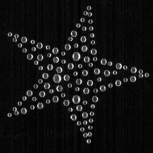 May include: A silver star-shaped design made of small, round rhinestones. The rhinestones are arranged in a pattern that creates a five-pointed star.