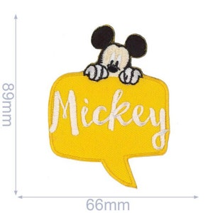 Op de afbeelding: Een gele geborduurde patch met het woord "Mickey" in witte letters. Een cartoon Mickey Mouse-personage staat boven de tekst. De patch is 6,6 cm breed en 8,9 cm hoog.