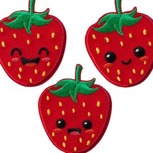 Könnte beinhalten: Drei gestickte Aufnäher in Form von lächelnden Erdbeeren. Jede Erdbeere ist rot mit grünen Blättern und gelben Samen. Die Erdbeeren haben schwarze Augen und lächelnde Münder.