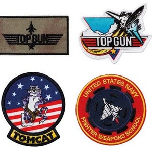 Könnte beinhalten: Vier gestickte Patches mit dem "Top Gun" Logo. Ein Patch ist in Tarnfarben grün mit dem Text "Top Gun" in Schwarz. Ein weiterer Patch ist in Blau und Weiß gehalten mit dem Text "Top Gun" in Rot. Der dritte Patch ist eine rot-weiß-blaue amerikanische Flagge mit einer Comic-Katze, die einen Pilotenhelm trägt und dem Text "Tomcat". Der vierte Patch ist ein roter Kreis mit dem Text "United States Navy Fighter Weapons School" in Gelb und einer schwarz-weißen Silhouette eines Kampfjets.