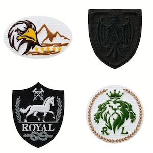 May include: Four embroidered patches with various designs. One features an eagle head, mountains, and stars. Another is a black shield with an eagle and the letter "A". The third is a black shield with a white horse and the word "ROYAL". The last is a green lion with the letters "R" and "L".