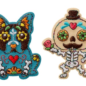 May include: Two embroidered iron-on patches featuring Day of the Dead designs. One patch is a blue and brown dog with a red heart and the other is a skeleton with a top hat and a red rose.