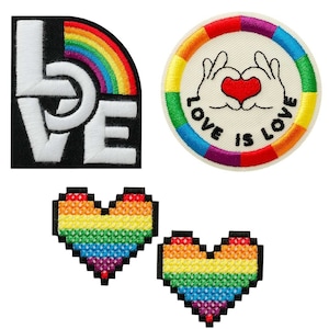 Könnte beinhalten: Vier gestickte Bügelbilder mit Regenbogen-Motiv. Ein Patch zeigt das Wort "LOVE" in weißen Buchstaben auf schwarzem Hintergrund mit einem Regenbogenbogen. Ein weiterer Patch ist ein Kreis mit einem Regenbogenrand und dem Text "LOVE IS LOVE" in schwarzen Buchstaben. Die letzten beiden Patches sind regenbogenfarbene Pixelherzen.