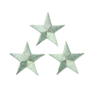 May include: Three silver embroidered stars on a white background.