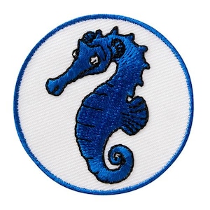 Op de afbeelding: Geborduurde patch met een blauw zeepaardontwerp. Het zeepaardje staat op een witte cirkelvormige achtergrond, met een blauwe rand. Geschikt voor kleding of accessoires.